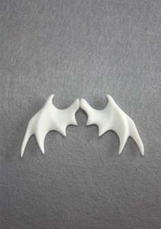 two white bats on a gray surface