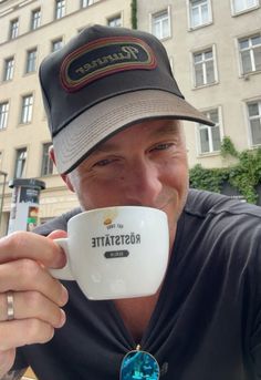 a man in a hat drinking from a coffee cup with the word roostaatie printed on it