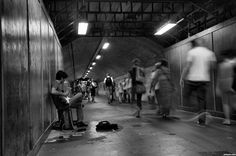 black and white photograph of people walking in subway