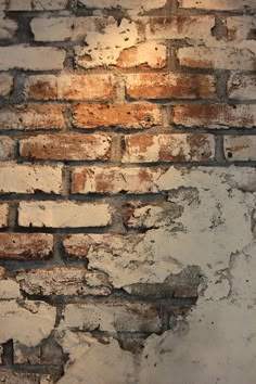 an old brick wall with peeling paint and light coming from the top right corner,