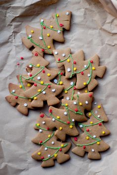 christmas cookies decorated with icing and sprinkles are on a piece of paper