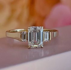 an emerald cut diamond ring with three baguets