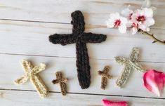 crocheted crosses and flowers on a white wooden surface