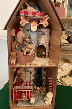 a wooden doll house with lots of christmas decorations