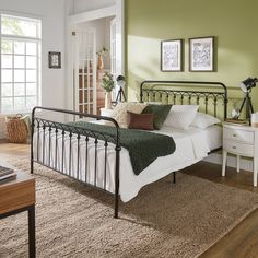 a bedroom with green walls and white furniture