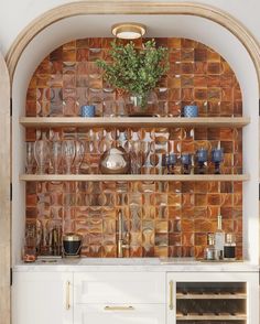 a wine rack with glasses and bottles on it next to a built - in oven