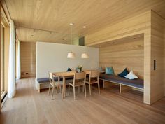 a room with wooden walls and flooring that has wood furniture on top of it