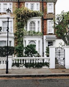 a large white building with many windows and plants on it