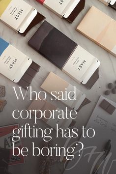 the words who said corporate gifting has to be boring? on top of many different colored books