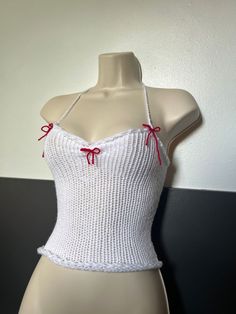 a mannequin wearing a white top with red bows