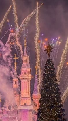 the castle is lit up for christmas and fireworks are in the sky above it,