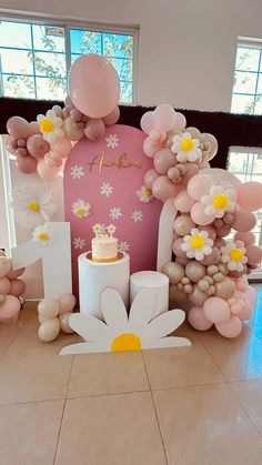 a table with balloons, cake and flowers on it