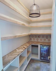 an empty room with shelves and a birdcage hanging from it's ceiling