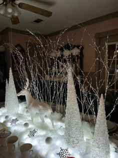 a table topped with lots of white christmas trees and snowflakes on top of it