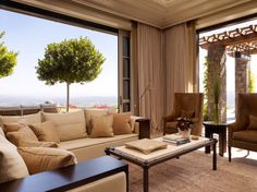 a living room filled with furniture and large windows