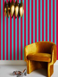 a yellow chair sitting in front of a red and blue striped wall