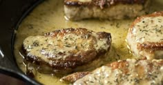 some pork chops are cooking in a skillet with gravy lemon thye pork chops