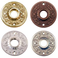 four different colored metal buttons with designs on them