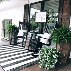 black and white striped rug on porch with rocking chairs, potted plants and welcome sign