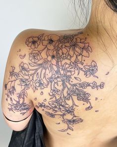 the back of a woman's shoulder with flowers on it