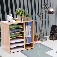 an office desk with a book shelf, lamp and bookshelf on the table