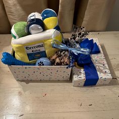 a gift box filled with baby items on top of a wooden table