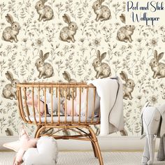 a baby sleeping in a crib next to a wallpaper with rabbits and flowers