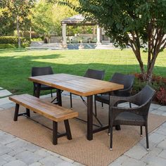 a table and chairs sitting on top of a rug in the middle of a yard