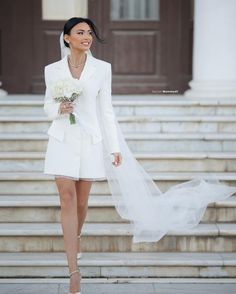 a woman in white is walking down the steps