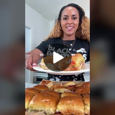 a woman holding a plate with sandwiches on it