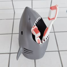 two toothbrushes in a shark shaped container