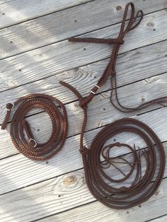 a brown rope on top of a wooden floor next to a pair of boots and a leash