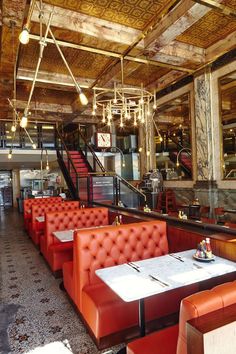 the inside of a restaurant with red leather booths