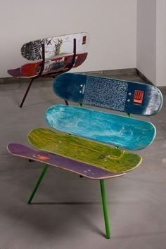 three skateboards stacked on top of each other in an empty room with concrete flooring