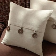 two white pillows sitting on top of a couch