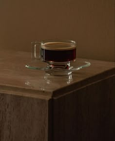 a cup of coffee sitting on top of a wooden table