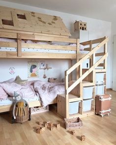 a wooden bunk bed sitting on top of a hard wood floor next to a white wall