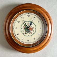 a wooden clock with floral designs on the face