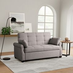 a gray couch sitting on top of a wooden floor