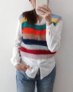 a woman is taking a selfie with her cell phone while wearing a colorful sweater