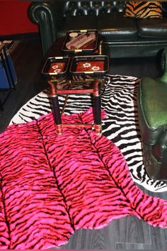 a zebra print rug on top of a wooden floor next to a chair and table