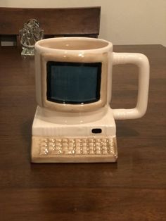 an old computer mug sitting on top of a wooden table