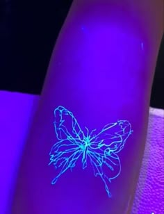 a close up of a person's arm with a glowing butterfly on the side