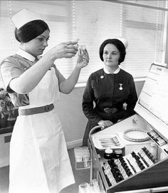 two women in nurses uniforms are drinking from glasses