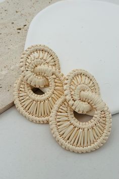 These unique earrings feature double hoops made from woven raffia straw, creating a playful and statement-making look. Perfect for adding a touch of quirkiness to any outfit, these earrings are sure to turn heads and showcase your personality! Post Back Iron frame Raffia Straw 2.25" Length 1.75" Width Raffia Earrings Diy, Chic Woven Summer Jewelry, Chic Summer Woven Jewelry, Chic Woven Jewelry For Vacation, Summer Vacation Braided Jewelry, Spring Vacation Woven Jewelry, Trendy Woven Earrings, Casual Hoop Earrings For Beach, Chic Hoop Earrings For Beach