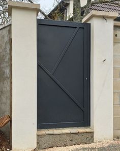 a black gate is open on the side of a house