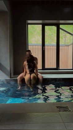 two people sitting in the middle of a swimming pool