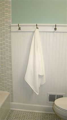 a white towel hanging on the wall next to a toilet