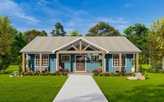 a small blue house in the middle of a grassy area with trees and bushes around it