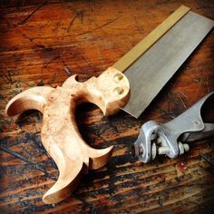 two woodworking tools on a wooden table with one knife and the other hand tool